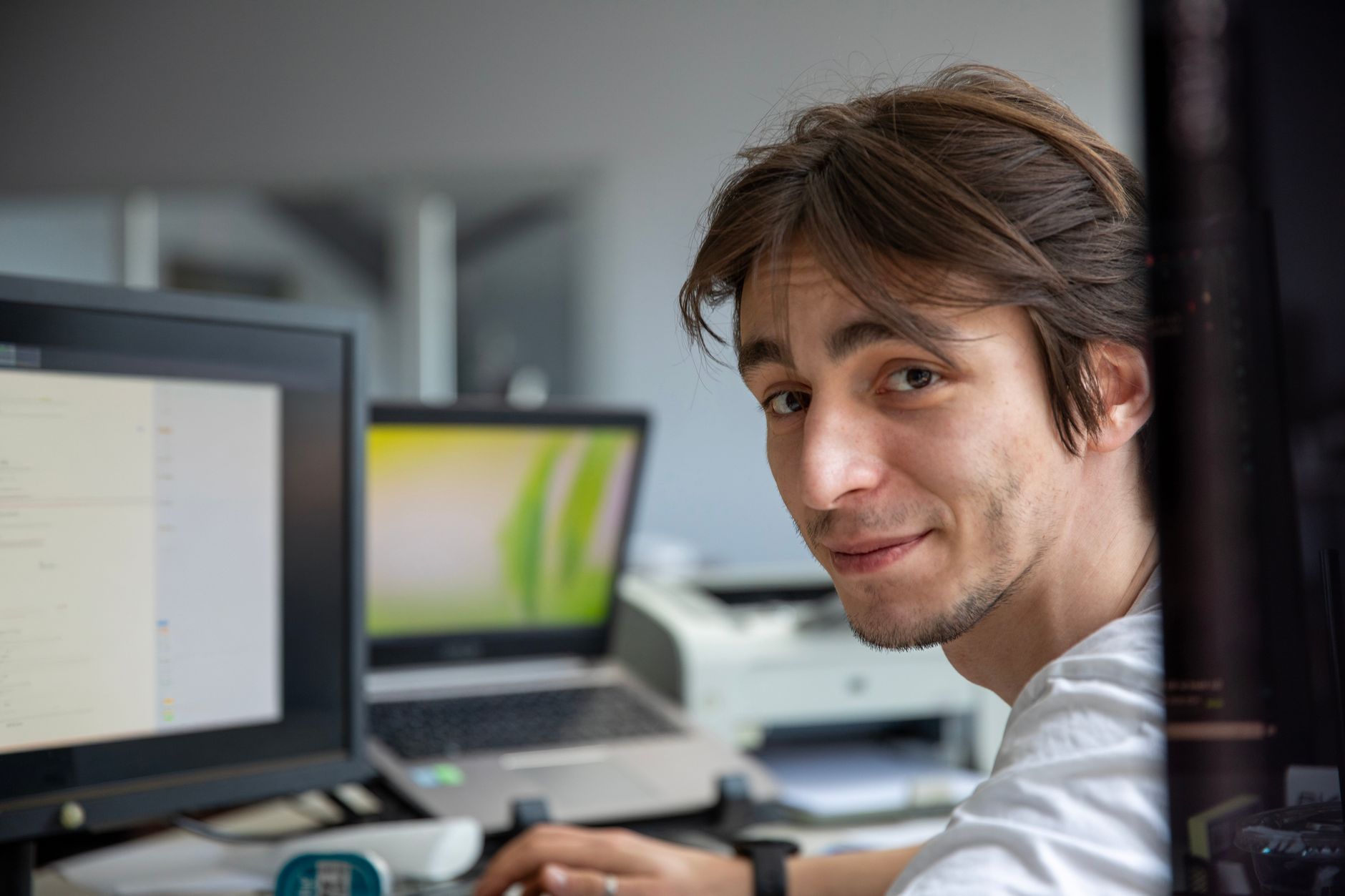 Joven profesional trabajando en su escritorio en un entorno de oficina contemporáneo.